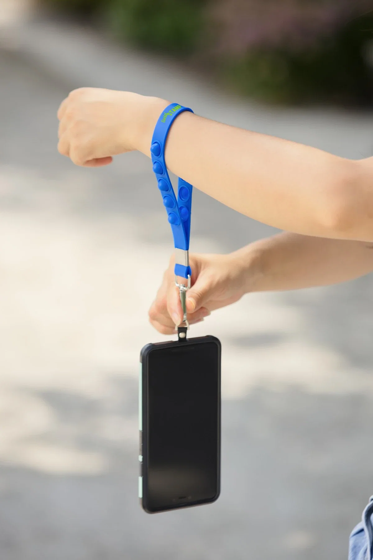 2-in-1 Push Pop Stress Reliever Phone and Keychain Wristlet held in hand