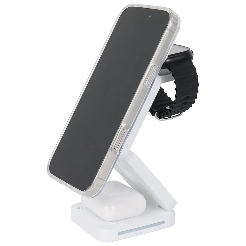 Apex 3-in-1 charging station on a desk, charging a smartphone beside a laptop