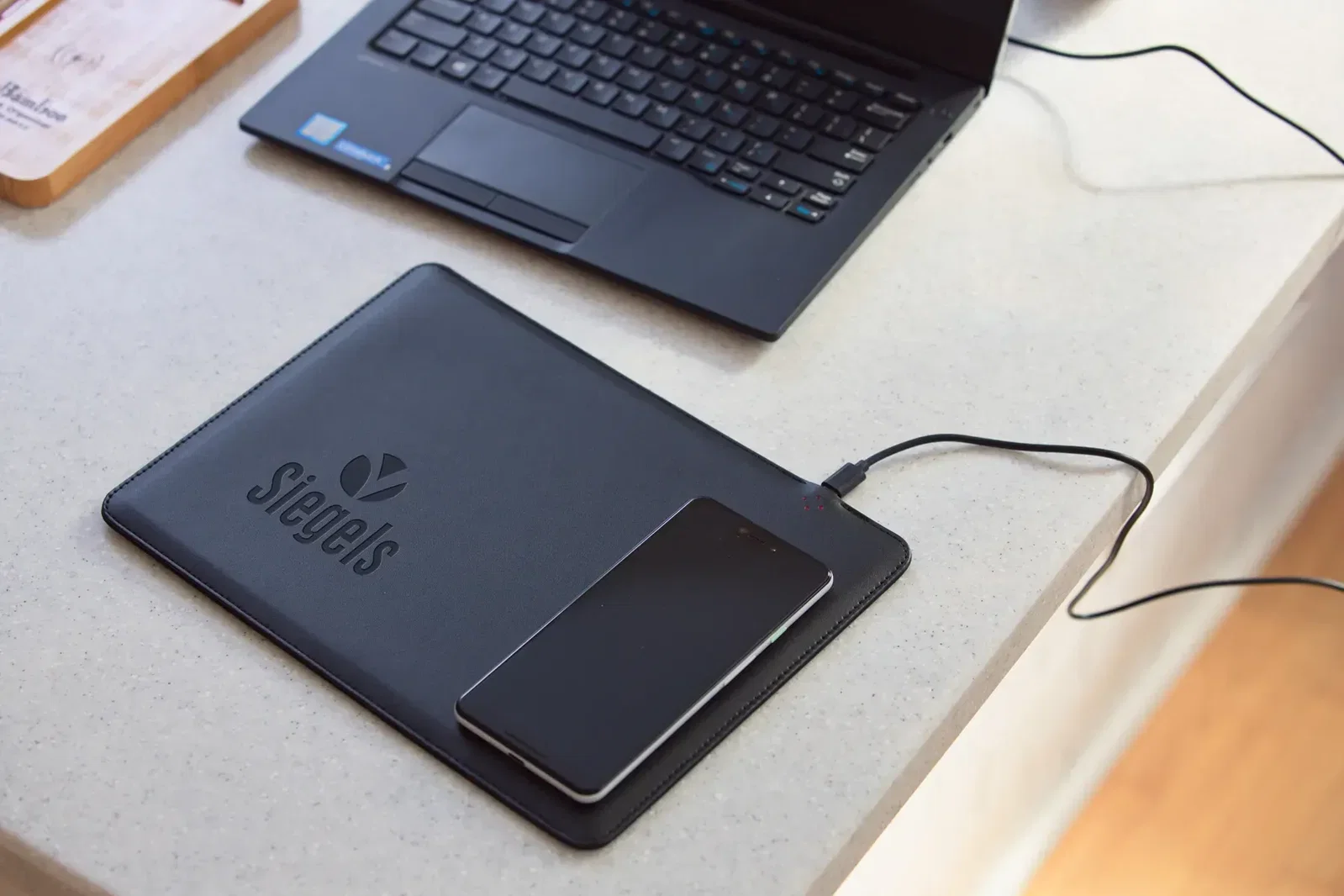 Branded Aspire mouse pad charging a phone, promotional 15W wireless charger surface