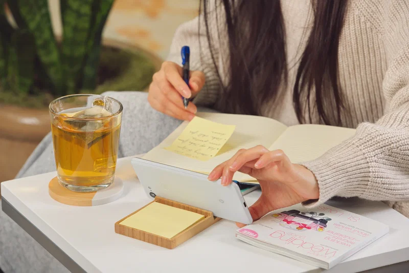 Promotional Bamboo Sticky Note Dispenser with Phone Holder on a desk, branded desk accessory lifestyle shot