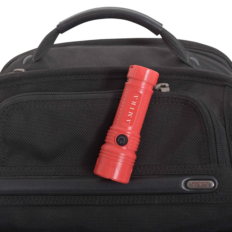 Red Best Buddy Tools® flashlight clipped onto a bag's zipper pull, showing the built-in clip attached to gear