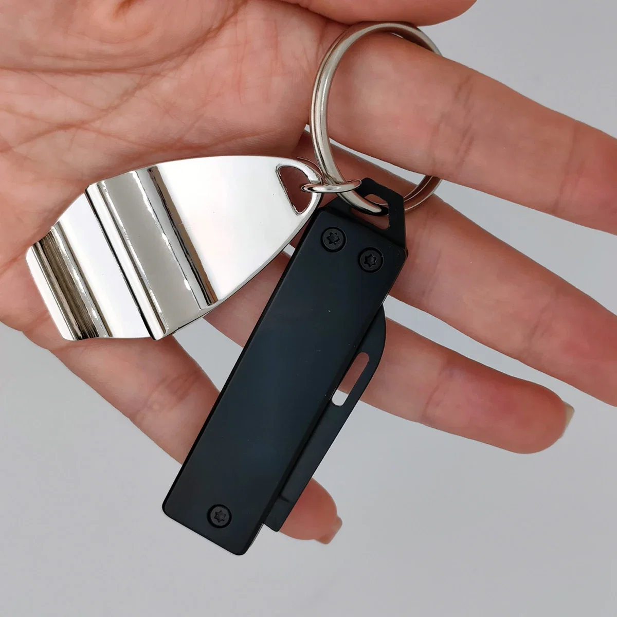 Branded Best Buddy Tools key chain pocket knife clipped to a keyring, in-use shot
