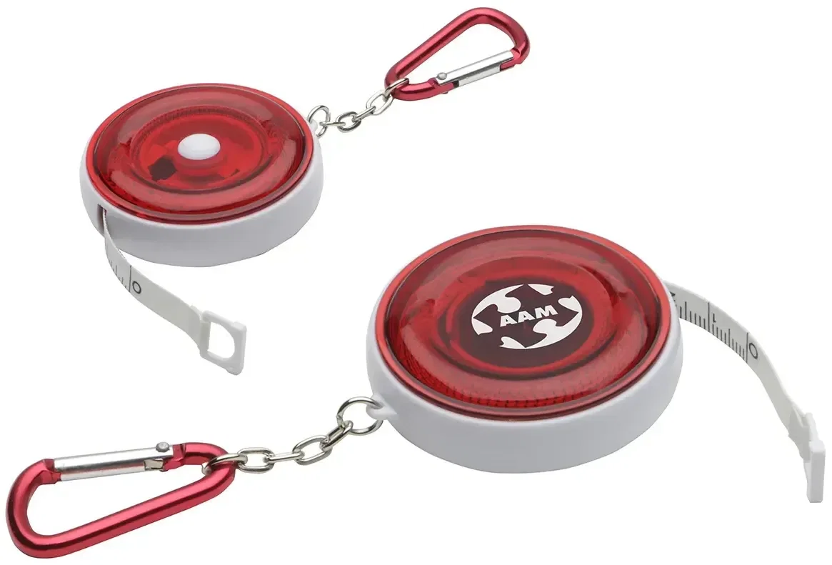 Promotional branded carabiner tape measure clipped to a bag, side view