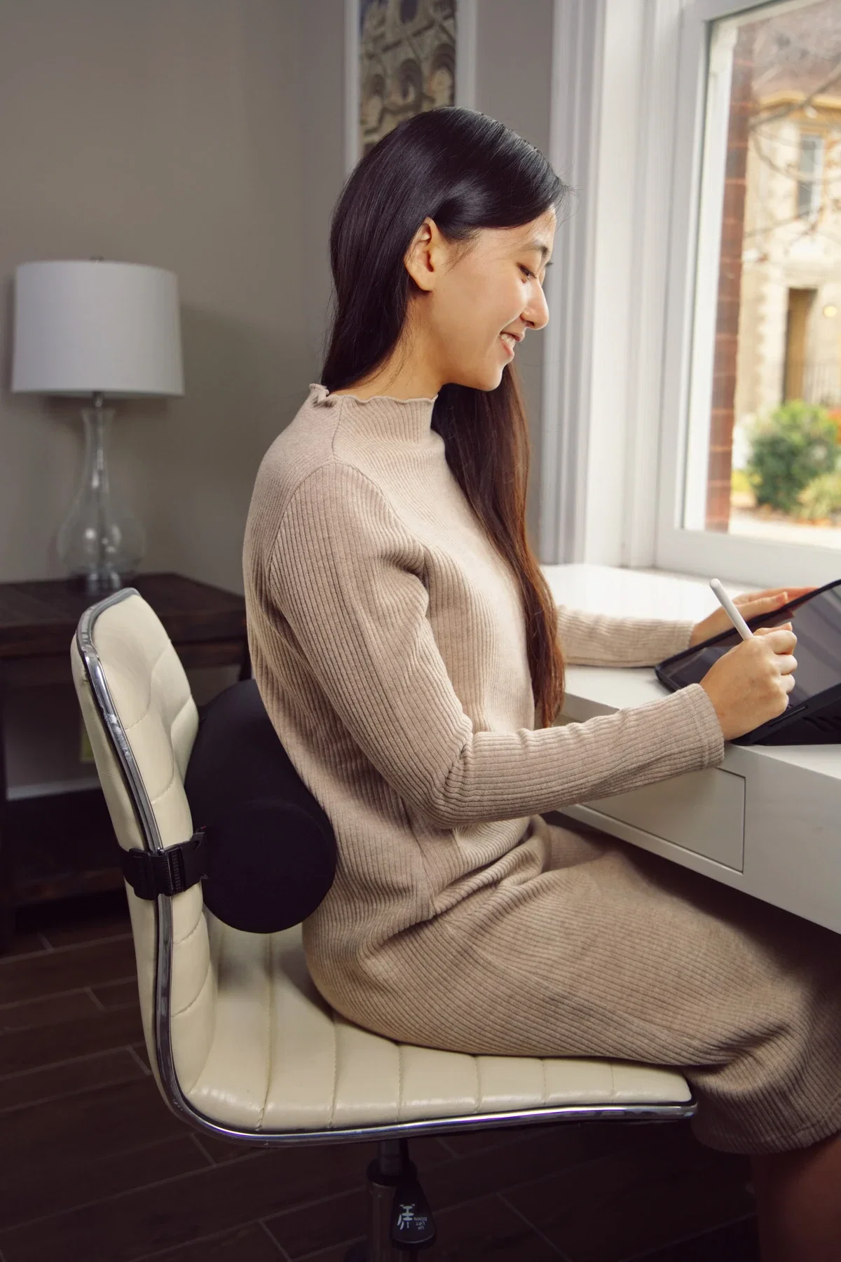 Comfort Logic Lumbar Support Roll Pillow in use behind a chair back, lifestyle shot