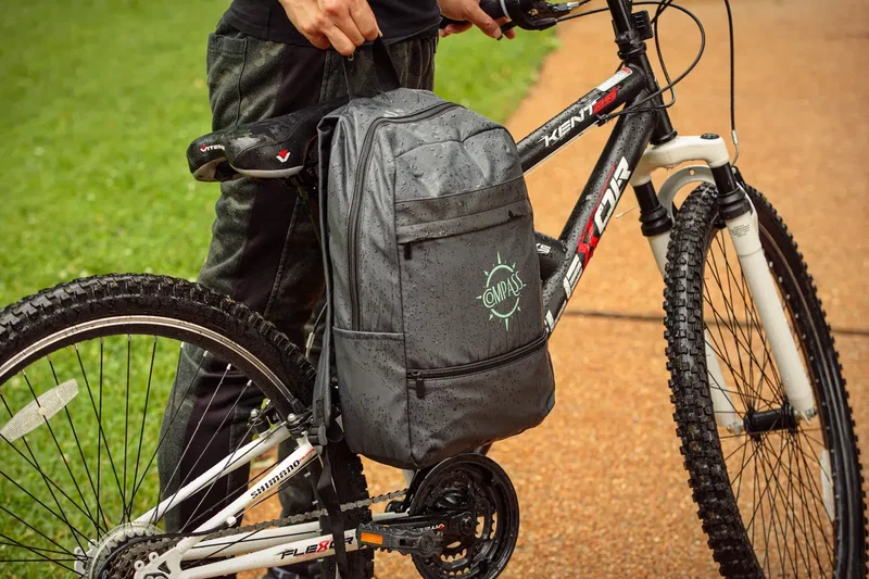 Custom branded Compass polyester backpack with padded straps, side angle view