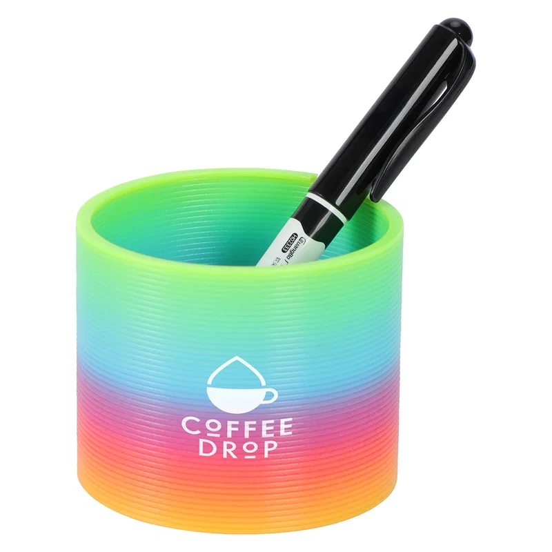 Dragon Spring Game collapsed into its cup shape in a rainbow gradient, with a pen resting inside for scale