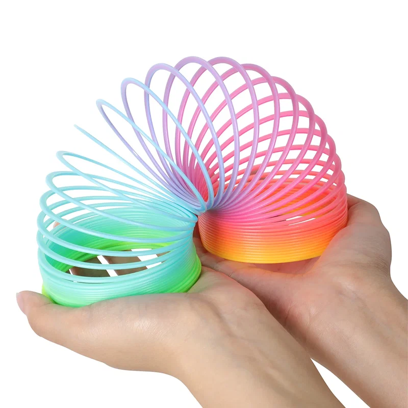 Close-up of the Dragon Spring Game's rainbow coil spring rings cupped in two hands