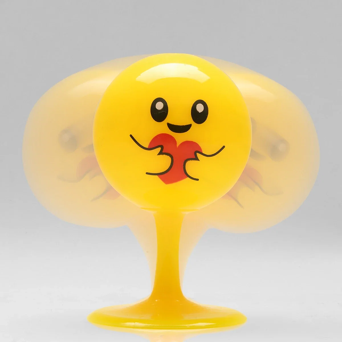 Close-up of the Emoji Bopper Desk Ball's heart-hug face design bobbling on its flexible stem