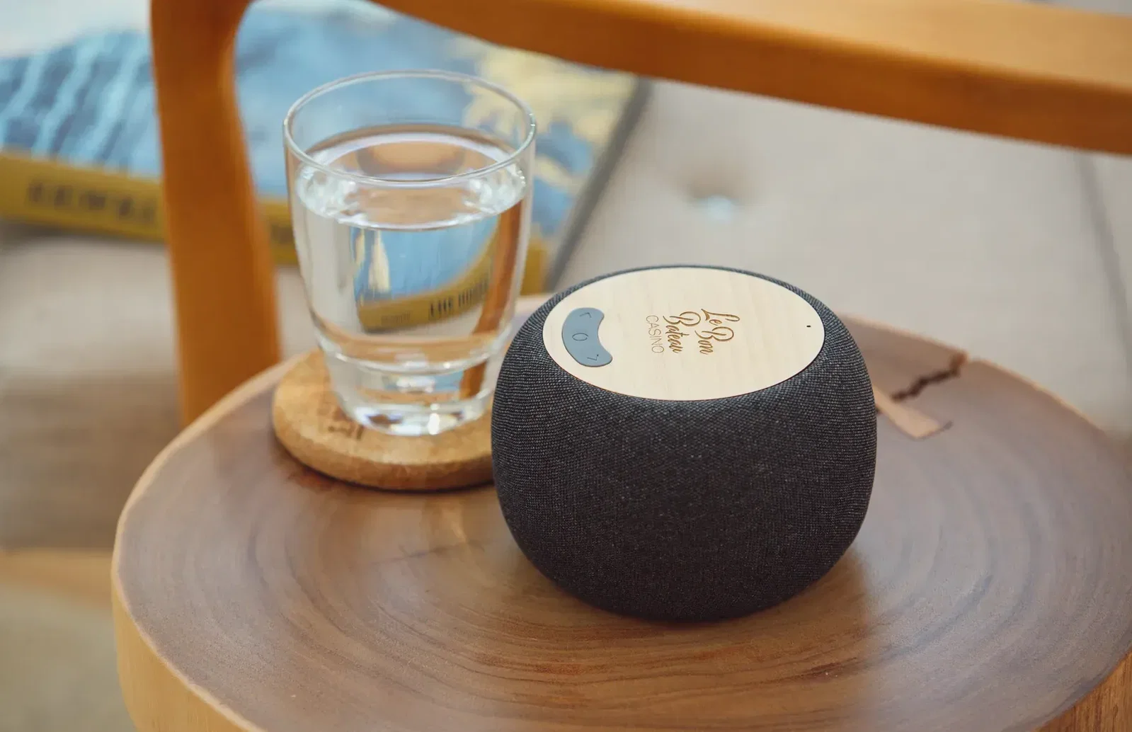 Branded Empire bamboo speaker charging a phone, promotional two-in-one wireless charger