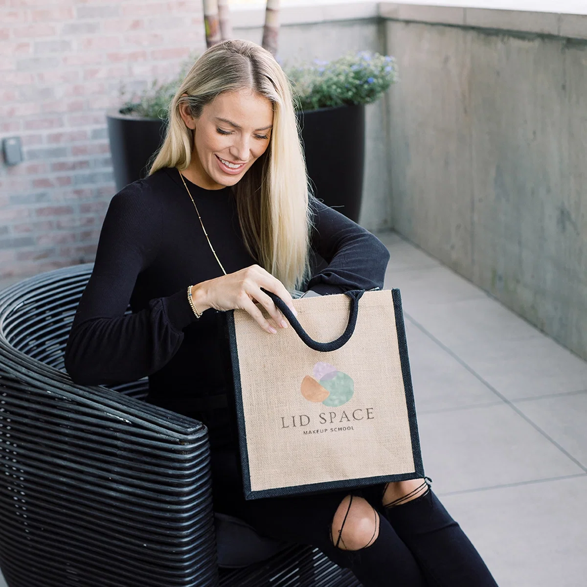 Imprinted Escape Jute Tote Bag held in hand