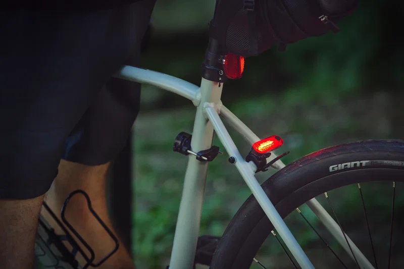 Custom Lucent bike taillight on a rider's bike after dark, branded promotional visibility shot