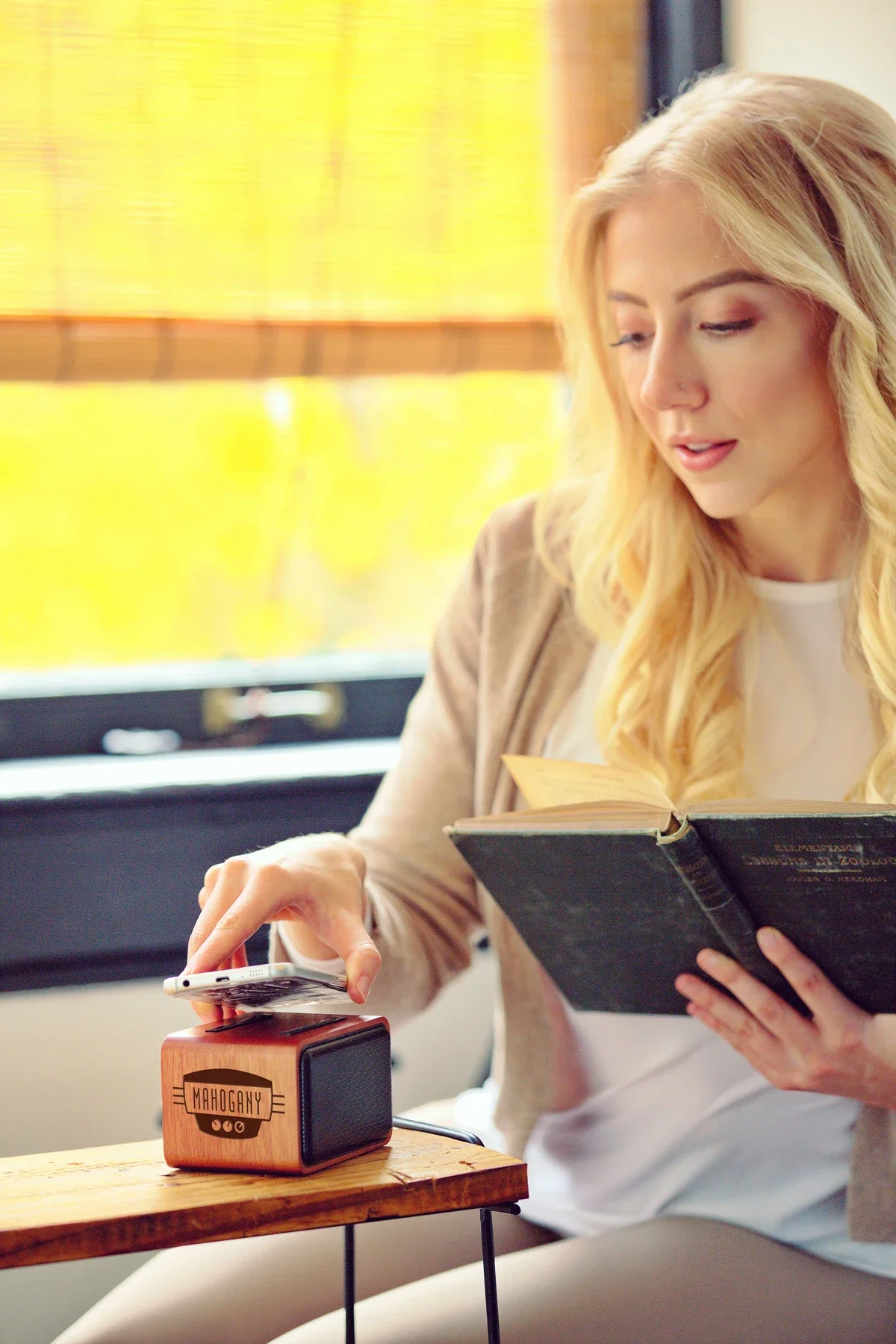 Mahogany Wireless Speaker with Wireless Charger in use