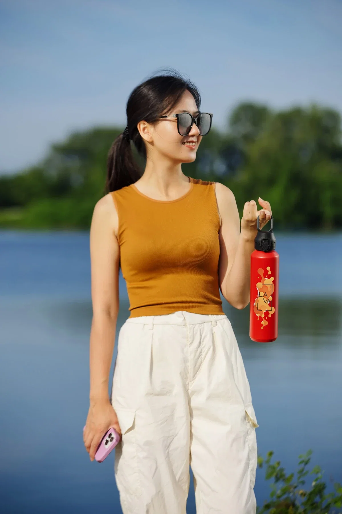 Nexus 27 oz Recycled Aluminum Bottle with Flip-Top Lid and Carabiner held in hand