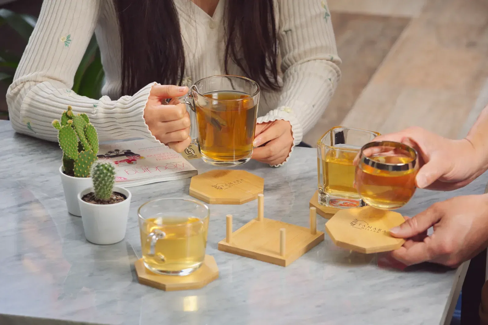 Octagon Bamboo 4-Piece Coaster Set held in hand