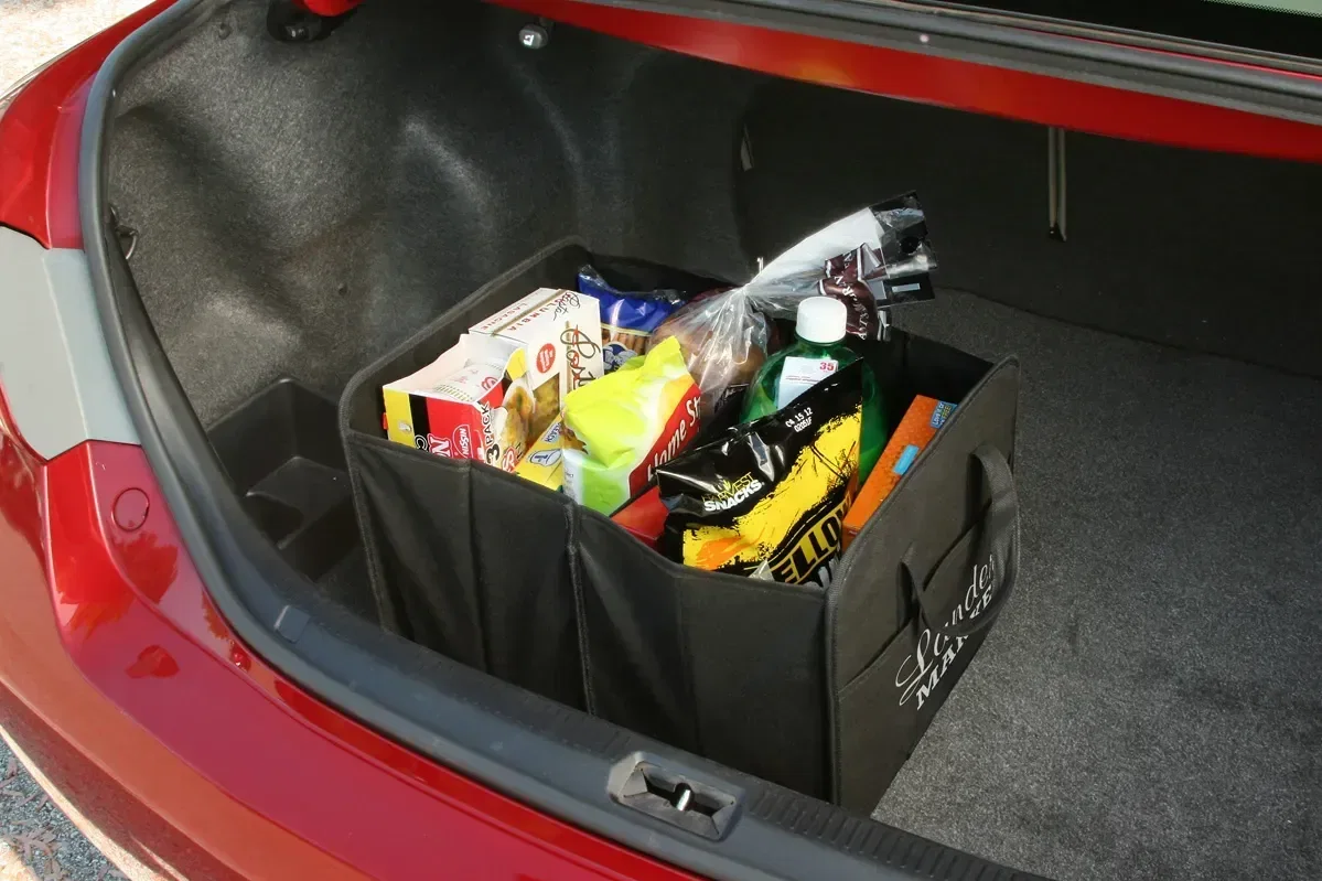 Branded Payload collapsible trunk organizer holding cargo, angled view