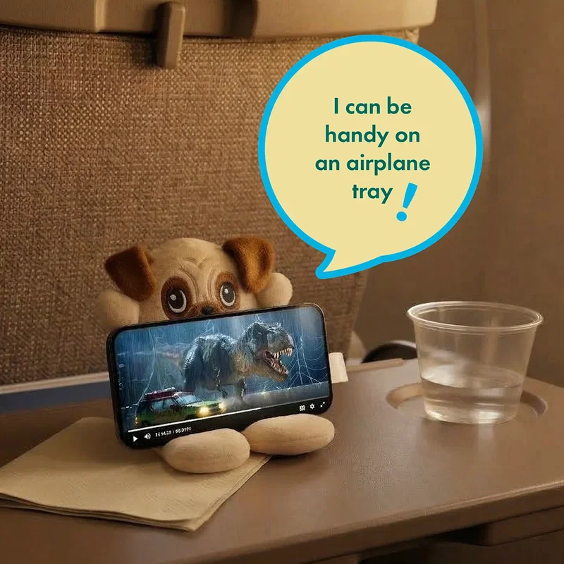 Angled view of the Phone Pals Weighted Plush Phone Holder resting on a desk, style 2 of 3