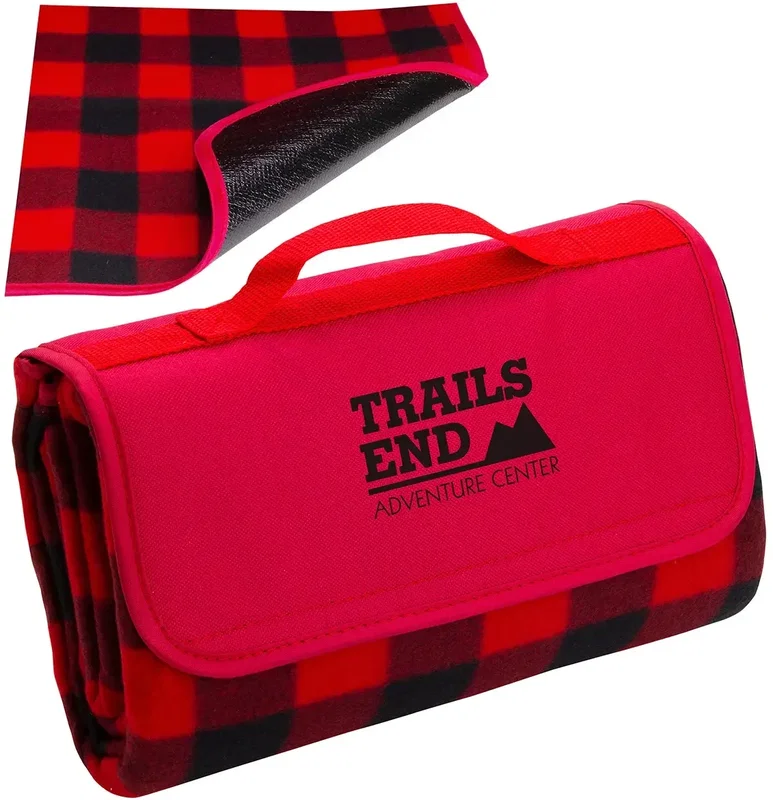 Branded plaid picnic blanket spread out on grass