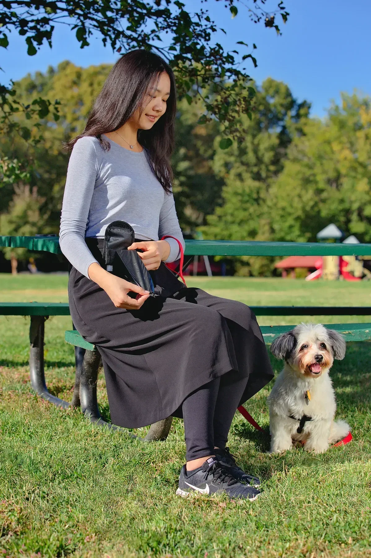 Custom branded pet waste bag holder clipped to a leash, side view