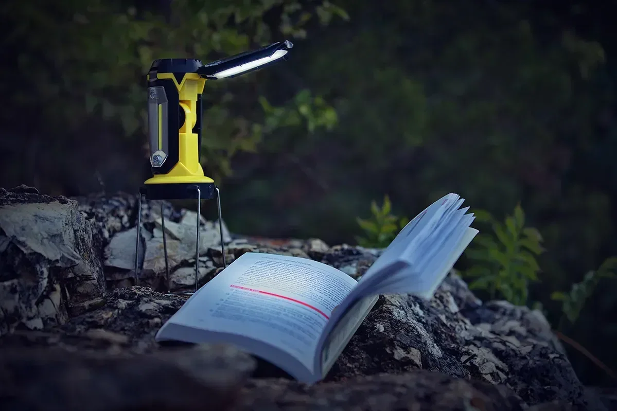 Promotional Quasar COB camping lantern with carry handle raised, angled view