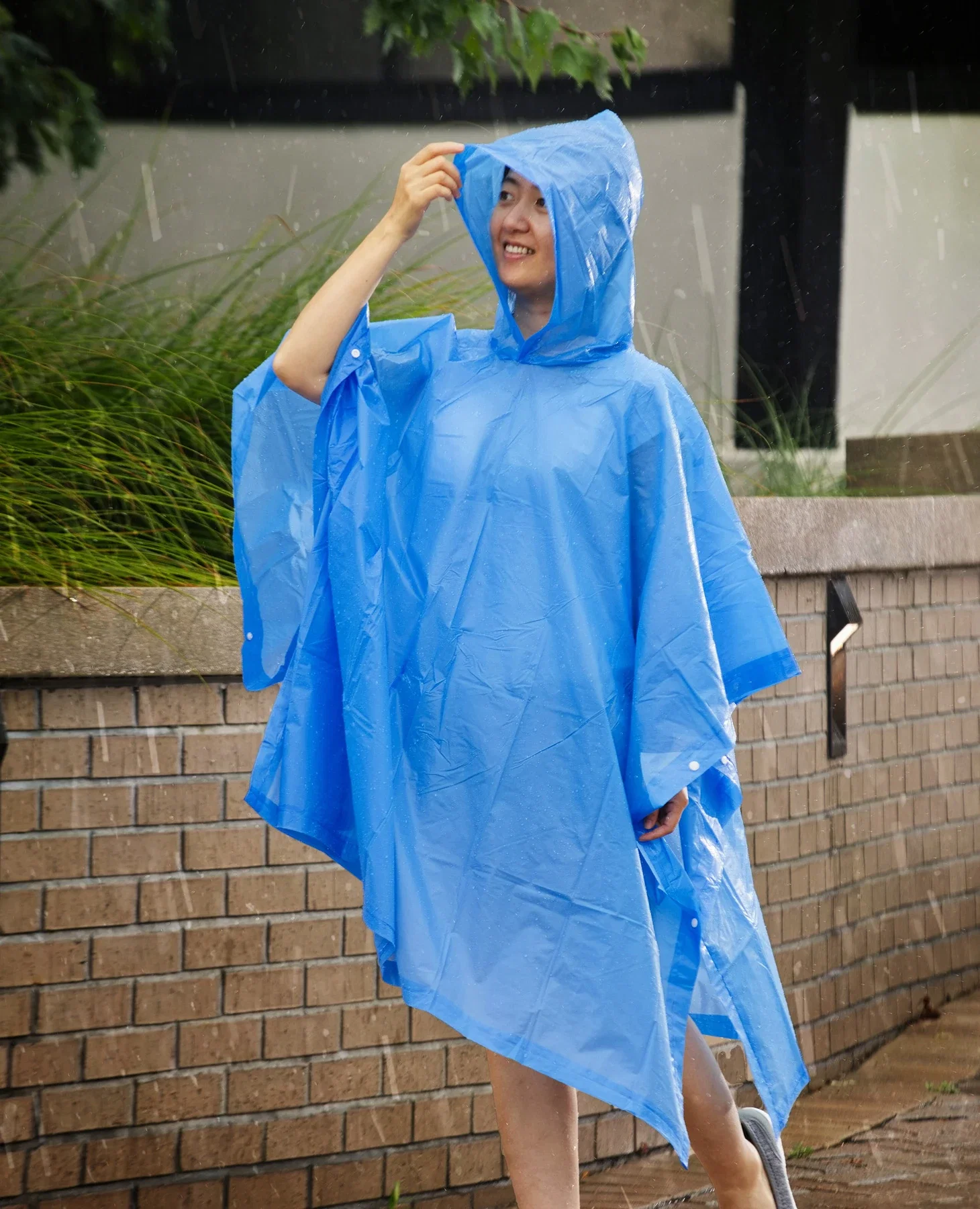 Rainshield PEVA Poncho worn outdoors in the rain, branded poncho lifestyle shot