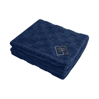 Checkered sherpa blanket folded to show the patterned face and plush backing