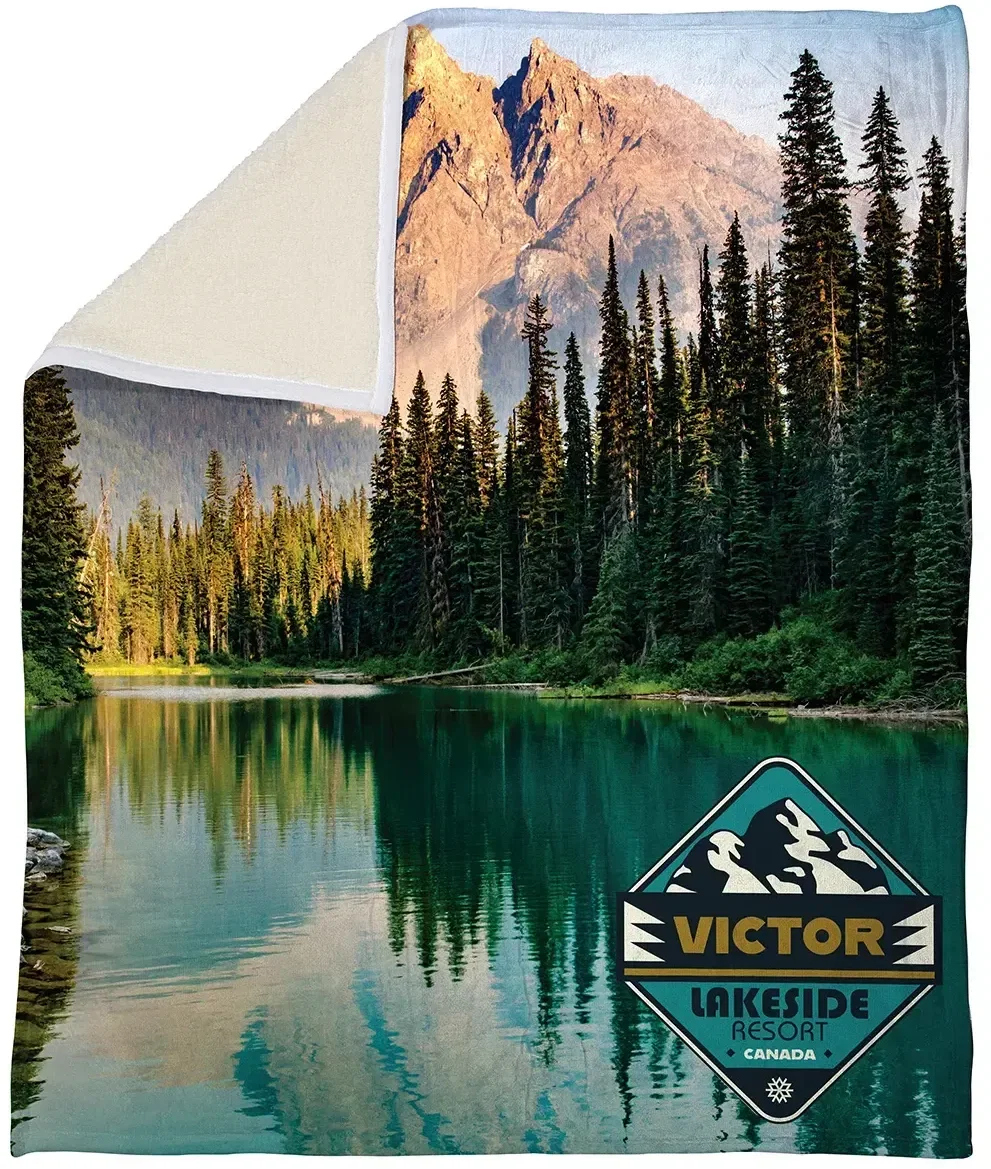 Corner detail of the branded Silk Touch sherpa blanket showing the plush sherpa back and logo
