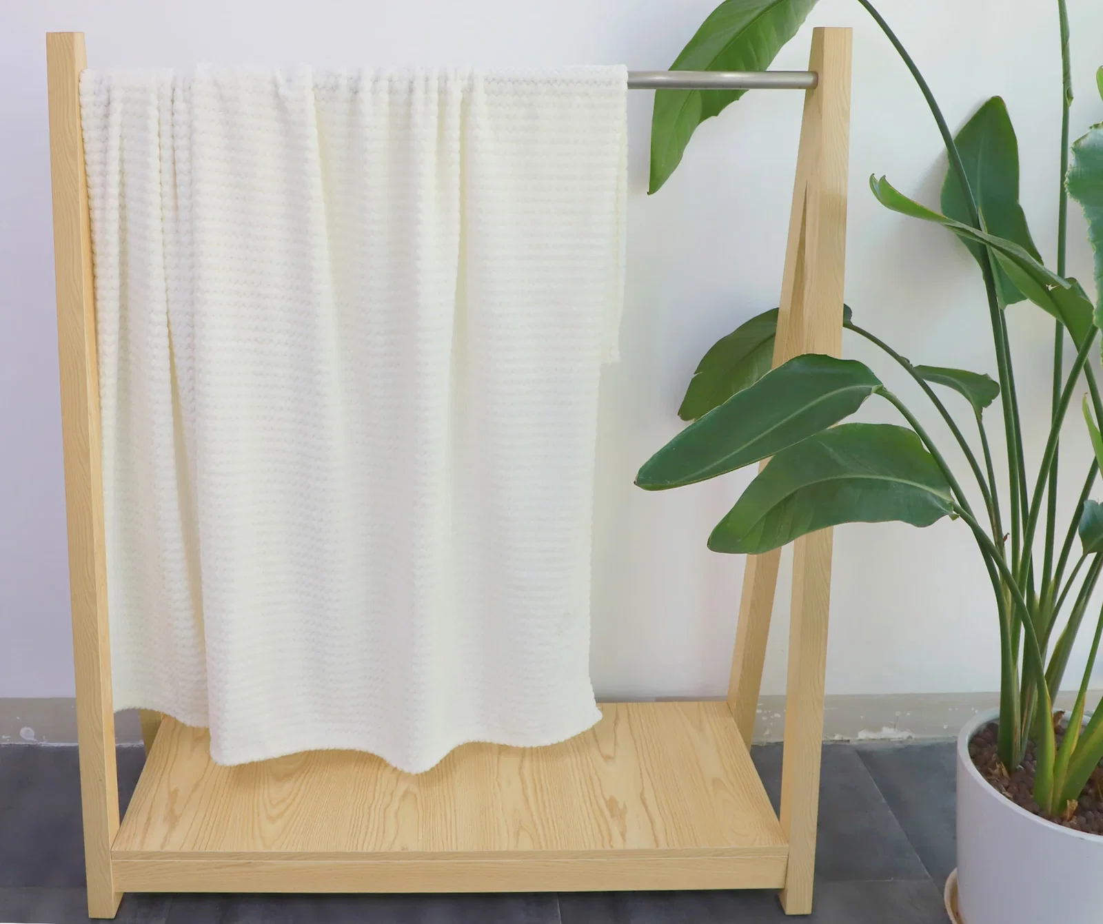 Snuggle Up blanket draped over a sofa, branded soft-textured blanket lifestyle shot