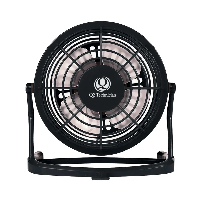 Fan running beside a laptop during the workday