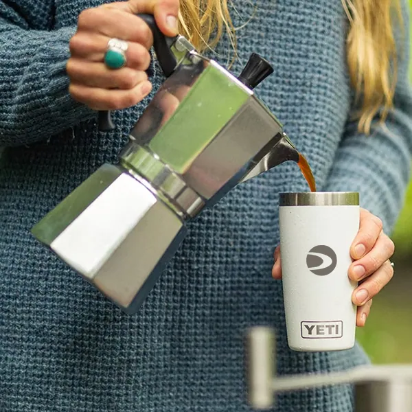 Custom-branded YETI tumbler with coffee being poured